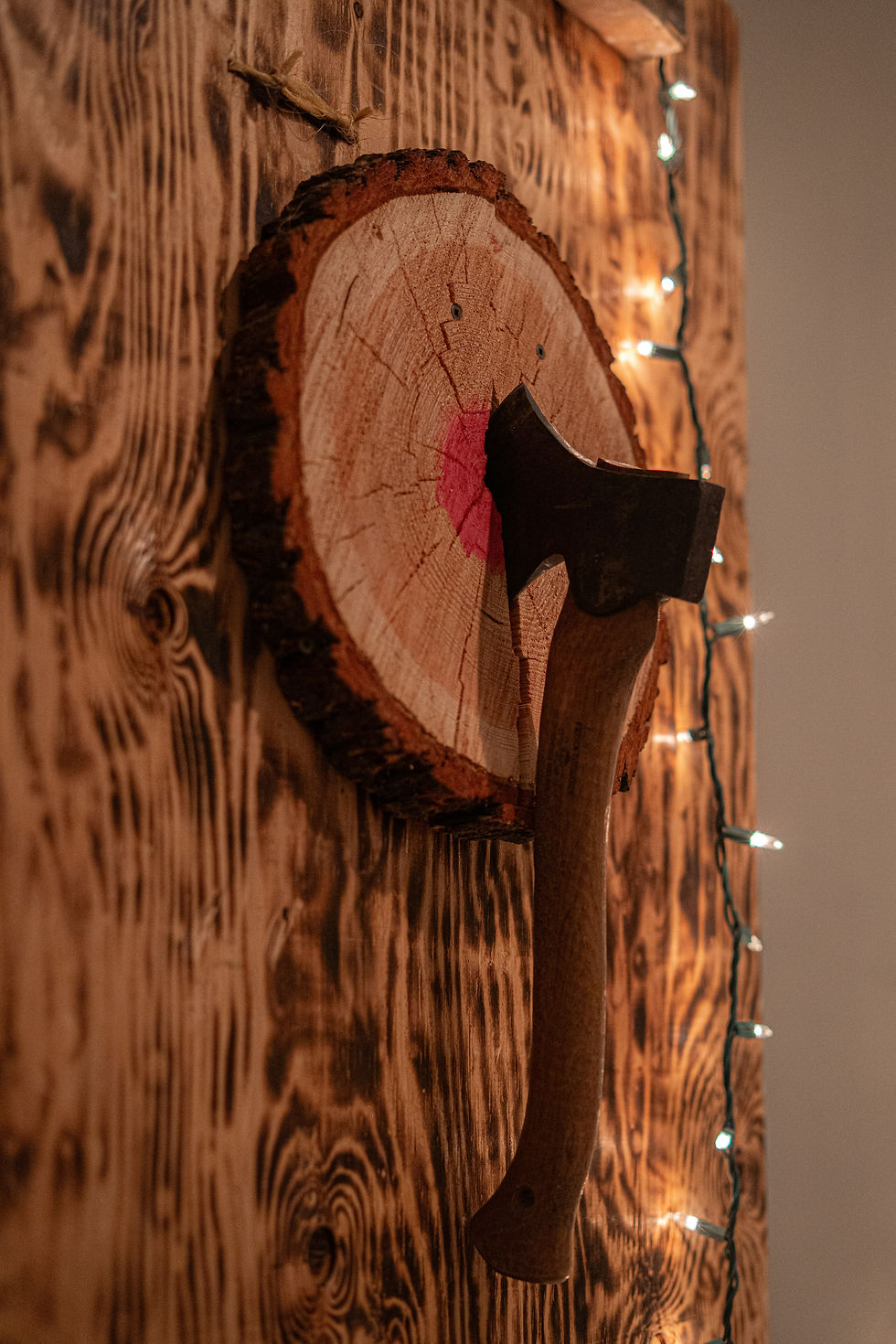 Close-up of an axe stuck in a wooden target with a bullseye