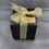 Thumbnail: Gift boxed uplifting aromatherapy soy container candles. Black box with gold ribbon and gold information stickers.