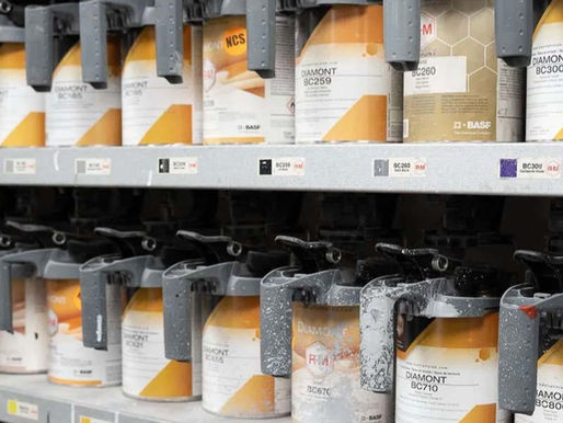 Rows of spray paint cans labeled "DIAMONT" on shelves, featuring gray nozzles and orange accents. Labels display various color codes.