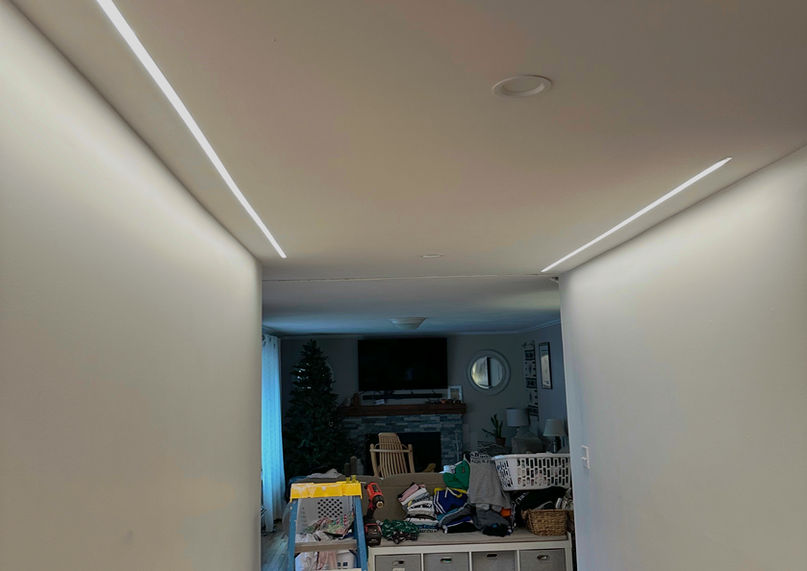 Modern recessed linear LED strip lighting installed flush in a residential hallway ceiling.