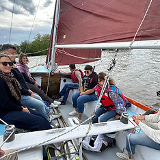 Balade en voilier à voiles rouges avec groupe de passagers sur une rivière par temps couve