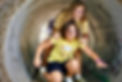 TVS students playing a guided game through the large cement tunnel on campus.