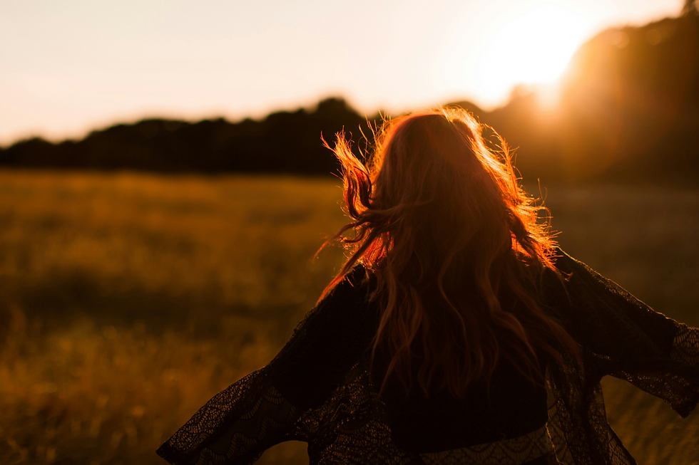 Frau im Sonnenlicht in der Natur als Symbol für innere Klarheit und Orientierung