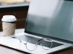 A computer, a pair of glasses, and a cup of coffee