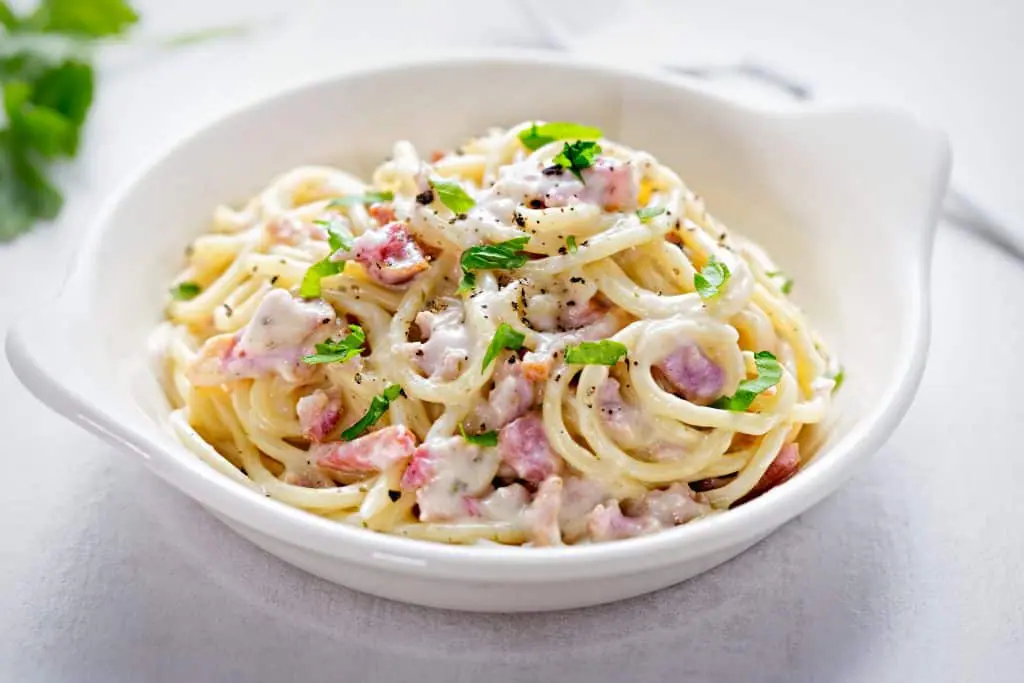 carbonara pasta in a white bowl