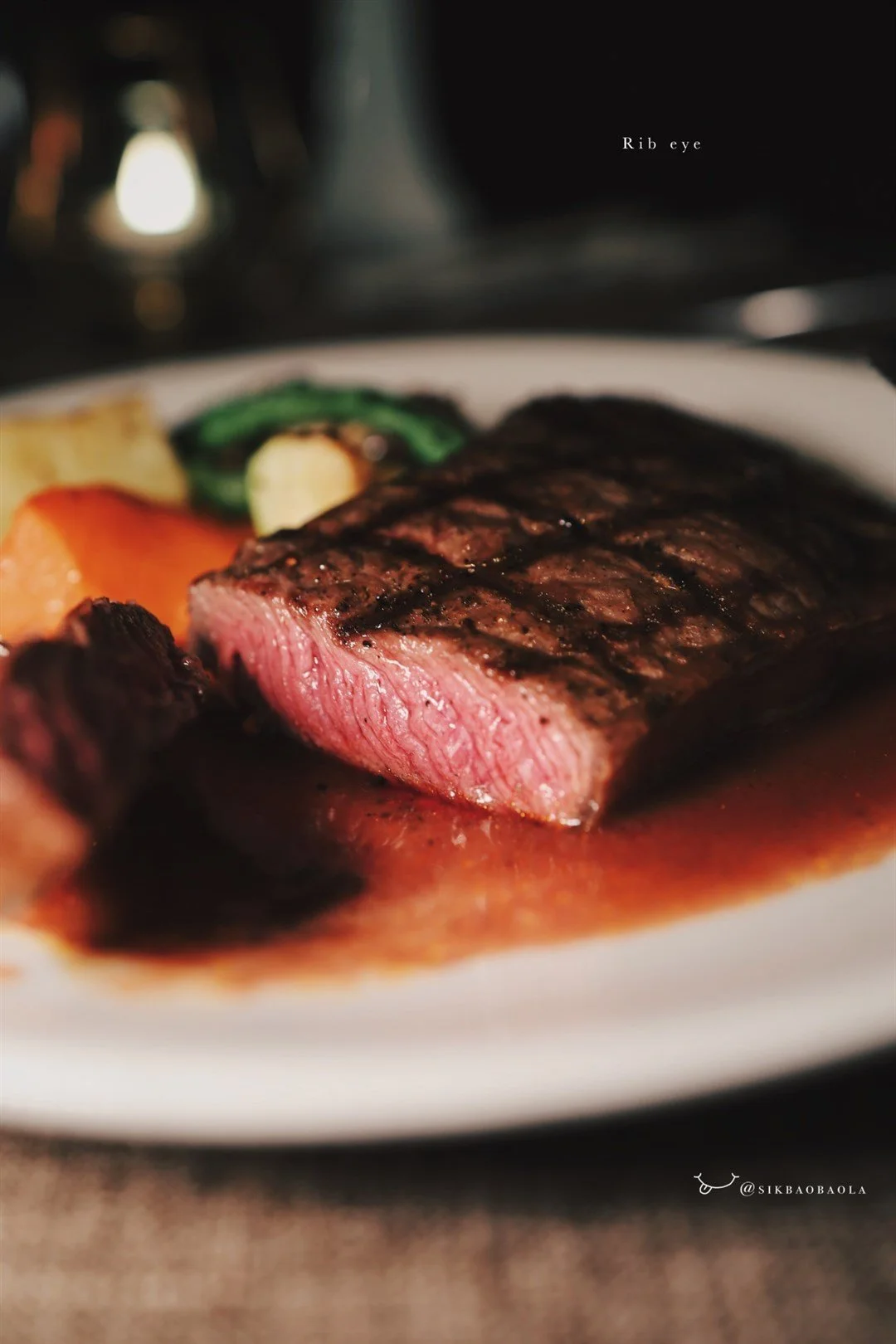 Grilled rib-eye being cut to show its medium rare temperature.