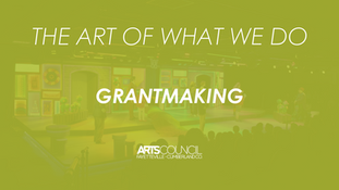 A wide, olive-green tinted photo of a stage setting with several large canvases and people. The text "THE ART OF WHAT WE DO" is at the top in white, and "GRANTMAKING" is in the center in a large, white font. At the bottom right, there is a logo for "ARTSCOUNCIL FAYETTEVILLE-CUMBERLAND CO."