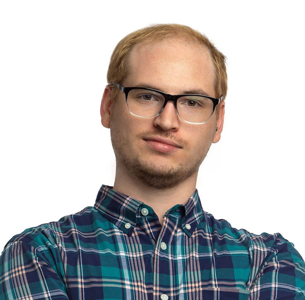 Portrait of a man with glasses in a blue plaid shirt, looking at the camera against a white background with a slight smile.
