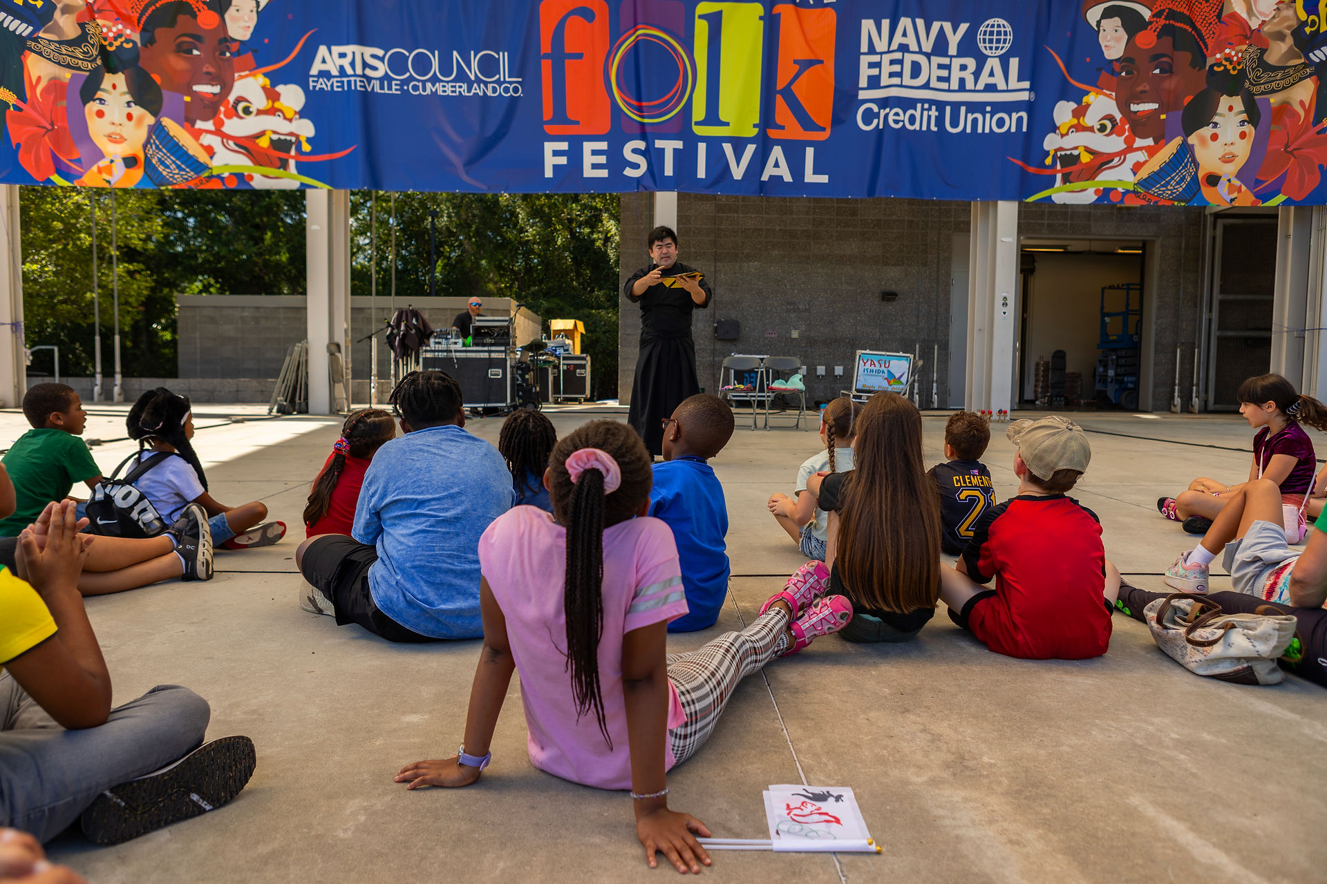Kids sit and watch performance at the 2024 International Folk Festival 