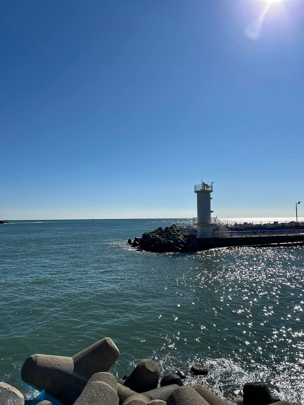 White lighthouse and blue ocean along the Gijang coast in Busan Korea