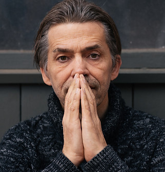 Mann mit Händen vor dem Gesicht gefaltet