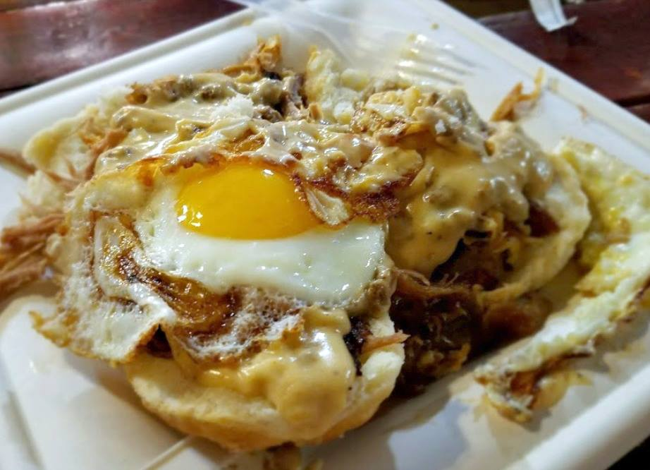 Brunch plate with biscuits, pulled pork, cheese, and a fried egg