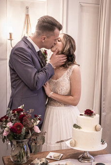 Brautpaar mit Hochzeitstorte und Brautstrauß