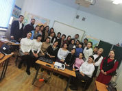 A group of teachers and presenters in a classroom gather together for a group photo