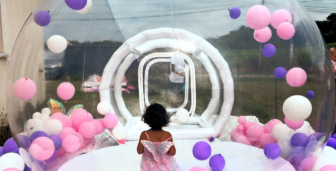 Petite fille portant une robe dans la Bubble House, ballons roses et violets.