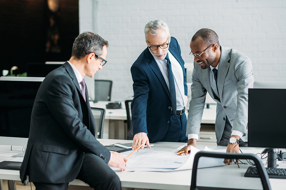 Experienced private equity and venture capital advisors from Orbit Coaching and Consulting collaborating over financial documents.