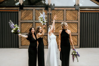 Bride and bridesmaids in black dresses celebrating