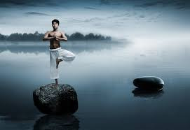 Dawn yoga, tree pose on a rock in a misty lake