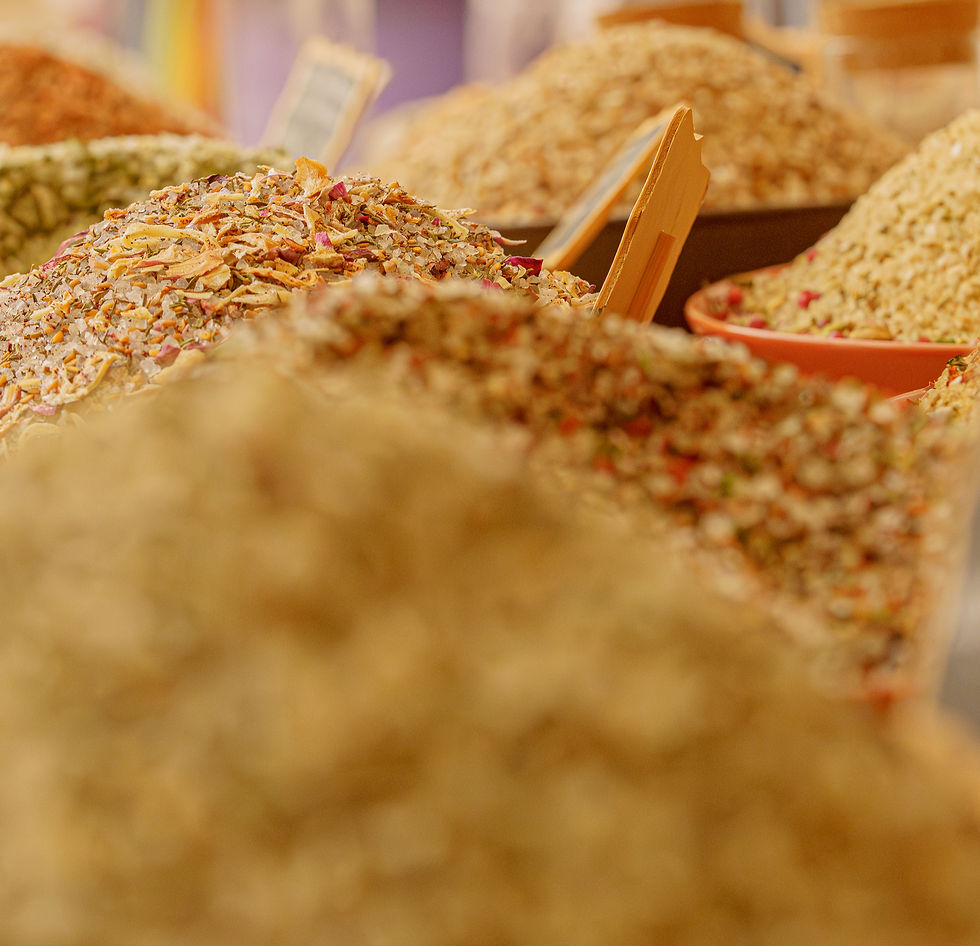Des étals de marché remplis de diverses épices colorées et aromatiques, avec des nuances de brun et orange, en ambiance chaleureuse.