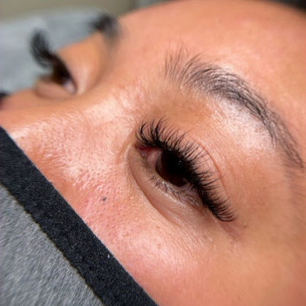 Close-up of eye with long, curled eyelashes and a black face mask