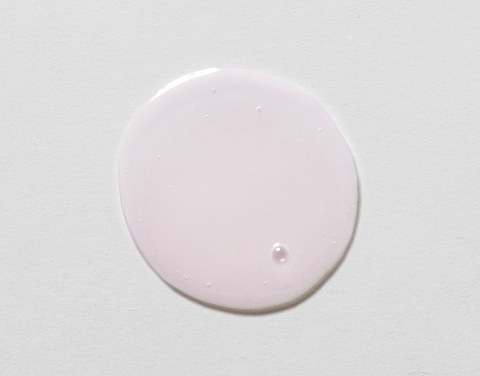 Pink lotion product abstract on a white background, skincare concept.