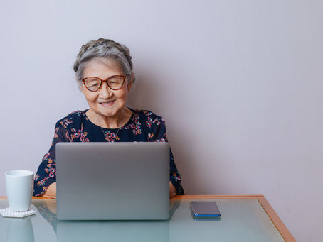 Senhora idosa escreve no computador