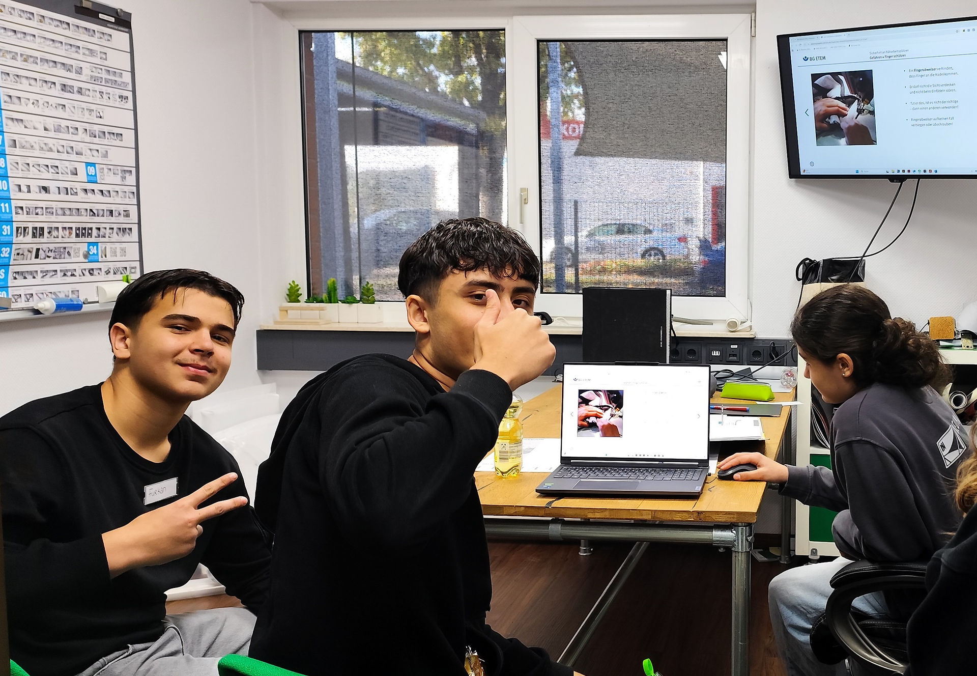Sitzen am Tisch am Laptop: Furkan, Mo und unsere Auszubildende Hanna