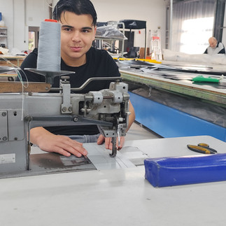 Furkan näht einige Probenähte bevor er sich das Polster vornimmt