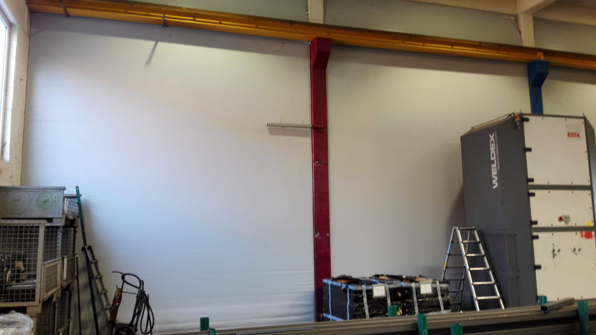 Hallentrennwand von Neumann Zelte und Planen aus Osnabrück, Trennwand aus grauser PVC Plane zur Abtrennung unterschiedlicher Bereiche, wir sehen eine werkstatt