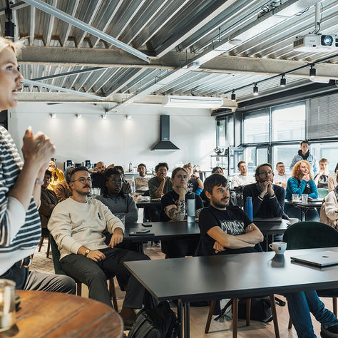 Calm and confident woman presenting to a large room of people