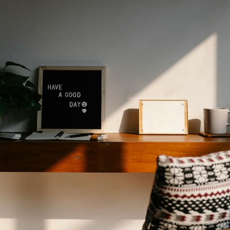 Warm light shining on a desk with positive inspirational decor, plants and colors