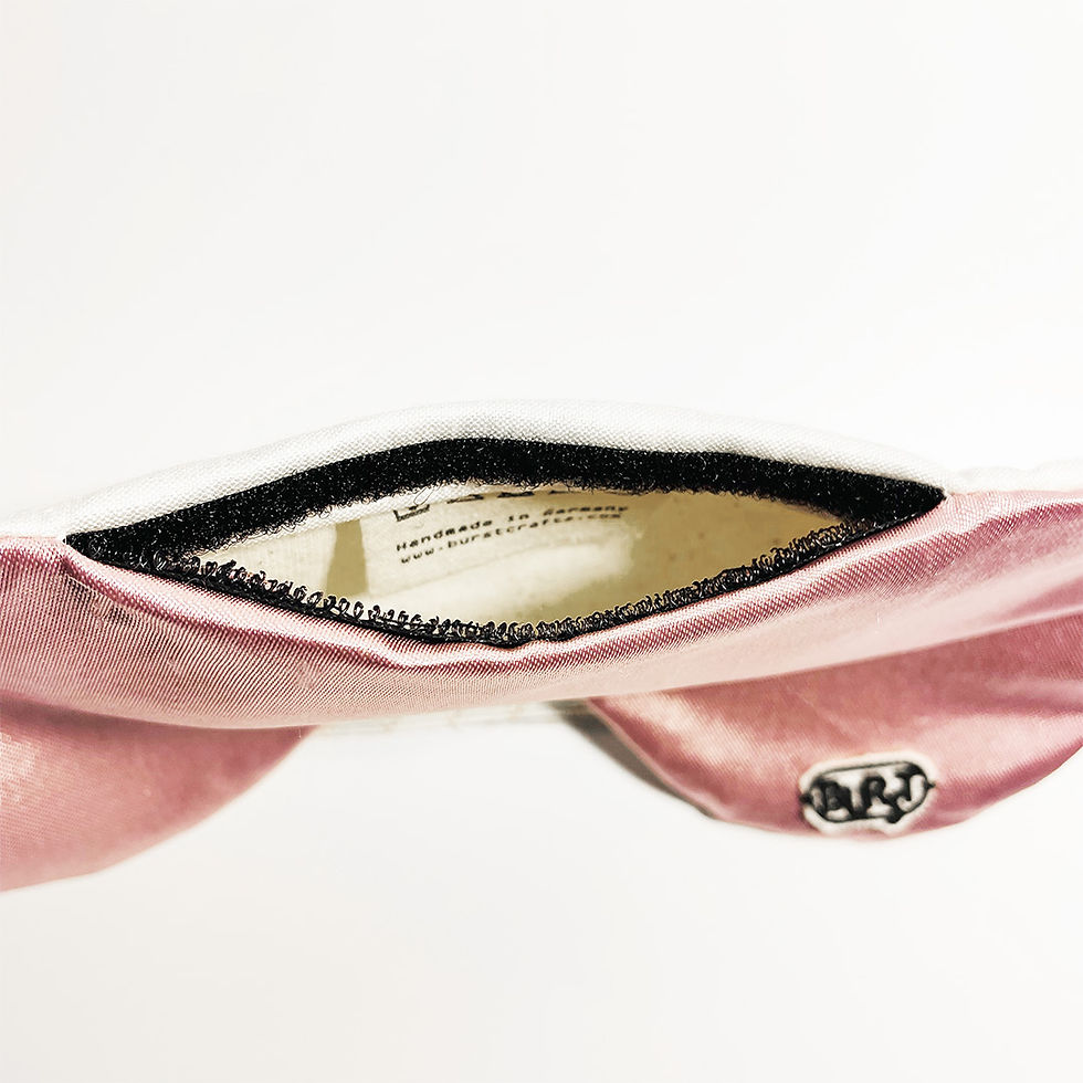 Thumbnail: handgemachte naturfreundliche schlafmaske in rosa satin von burst klettverschluss öffnung auf weißem hintergrund