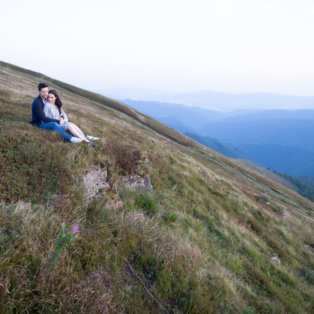 A couple sitting on a hillside.