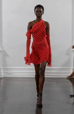 A red asymmetrical one-shoulder mini dress with off-the-shoulder long sleeves, from the Maximilian Davis Spring 2022 collection runway presentation at London Fashion Week