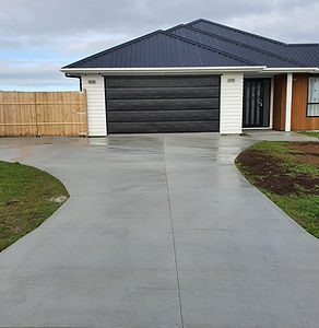 Modern house with a gray driveway and black garage door, JCE Water Blasting ltd