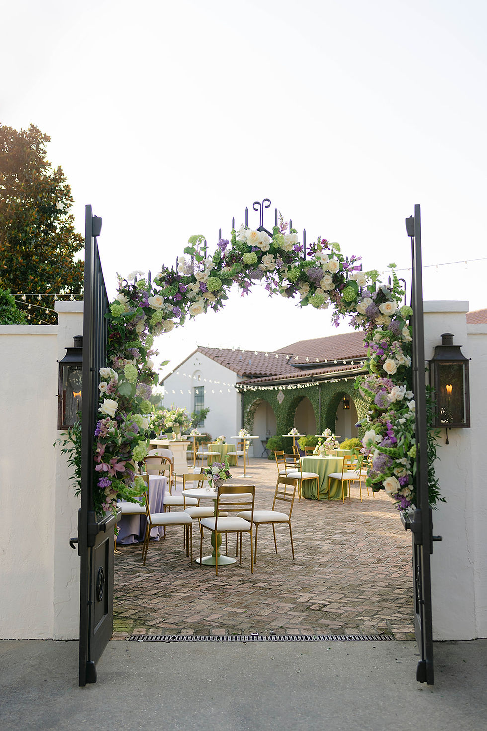 Garden-inspired floral entrance installation at Il Mercato in New Orleans featuring lavender, chartreuse, blush and ivory flowers.