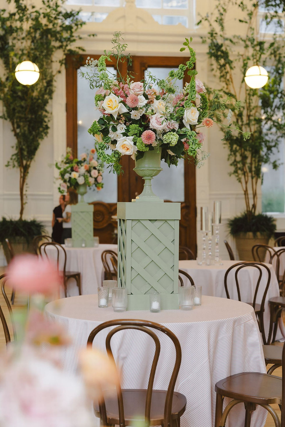 Large garden-style floral urn on a green lattice pedestal at Board of Trade New Orleans.