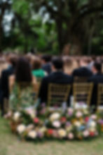 Wedding ceremony aisle lined with colorful spring flowers at the New Orleans Museum of Art sculpture garden.