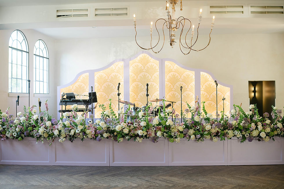 a custom made stage front and stage with florals designed by Leaf + petal at a wedding at il mercato in new orleans