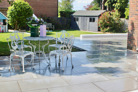 Porcelain Tile Patio with white table and chairs by Agile Landscapes