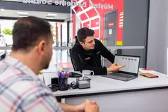 Müşteri Bekleme Alanı yazılı yerde iki kişi konuşuyor, dizüstü bilgisayar. kurumsal tanıtım filmi istanbul