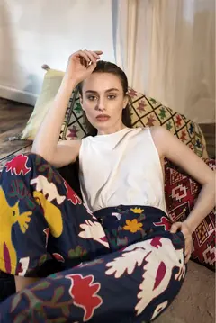 Beyaz bluzlu güzel kadın, yastıklarla oturuyor, fotoğraf ve video prodüksiyon istanbul.