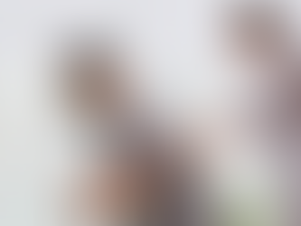 Female therapist gives back massage to man leaning face-first into a chair, in a bright room with white curtains and a plant; medical massage therapy