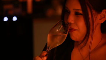 A lady is drinking champagne.