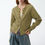 Thumbnail: green knit cardigan front view styled with pleated denim trousers