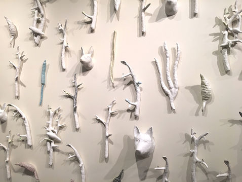 Wall installation with cast nature forms, branches, birds, dog and rabbit mount heads.