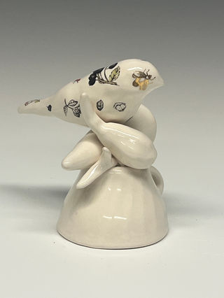 Cast porcelain bird covered in nature drawings of seeds and berries with nature forms and cup.
