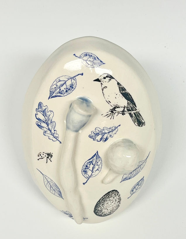 Cast porcelain form covered in nature drawings of seeds and berries with relief cast nature forms