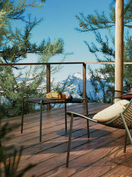 A serene retreat with a cozy chair, cushions, and a table set for a relaxing moment amidst the chaos.
