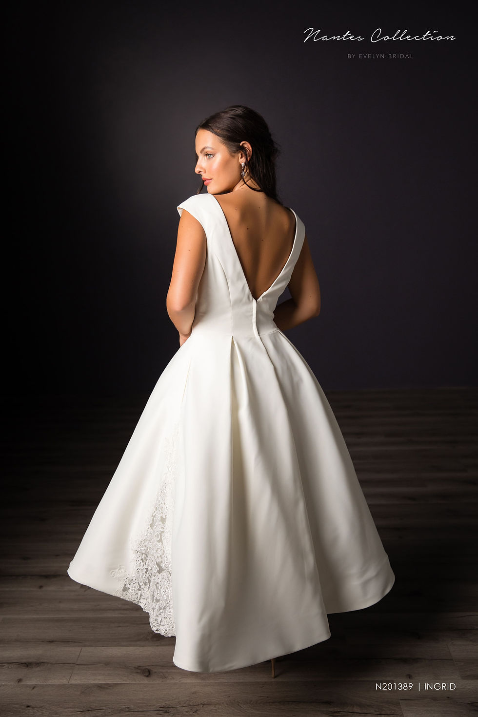 An exquisute short satin ball gown with sheer lace panels on the skirt area, two pockets loacted on sides of skirt, and a low V back.

Ingrid | N201389
Gown Info
An exquisute short satin ball gown with sheer lace panels on the skirt area, two pockets loacted on sides of skirt, and a low V back. The short skirt detailed with the small lace panels on the sides allows for a more elegant style. Pleats in the waistline make the skirt fuller looking, while allowing access to the pockets on the side of the skirt as well. The gown has a higher neckline and lower V-back for a one-of-a-kind design.

Material
Lace

Tulle

 

Color & Size
Ivory/Ivory (Shown)

 

Sizes available in 2-28  / 14W-32W